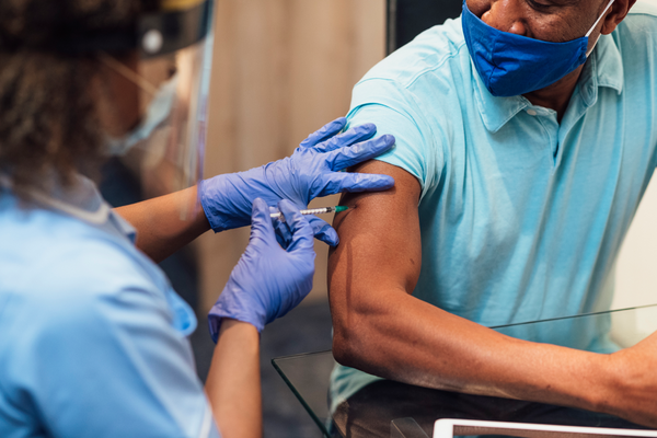 Health provider giving a man a vaccine shot