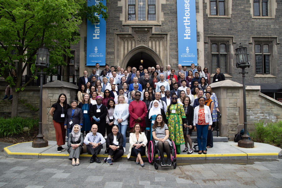 photo of group of adults smiling at a camera infront of the Hart House