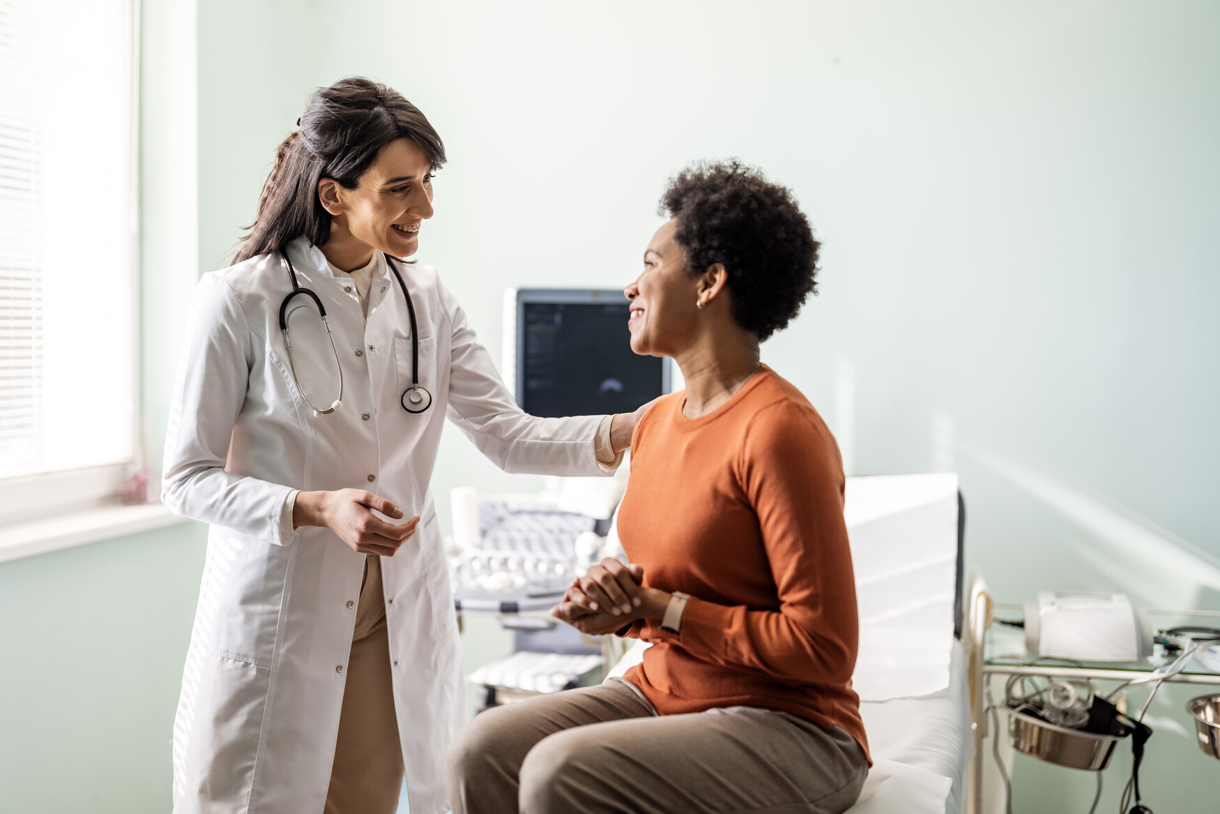 Female medical practitioner reassuring a female patient