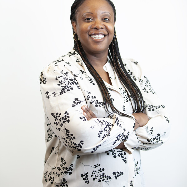 woman smiling at camera with hands folded